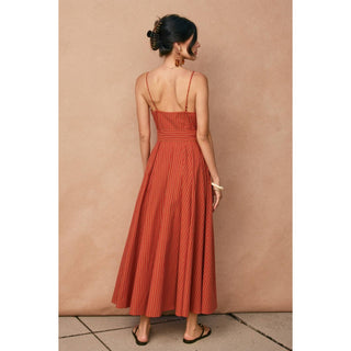 Woman wearing a red dress against a beige wall