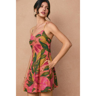 Woman wearing a pink floral dress against a beige background