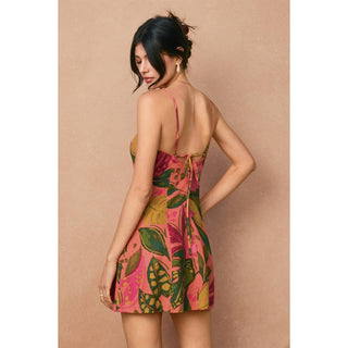 Woman wearing a colorful floral dress against a beige background