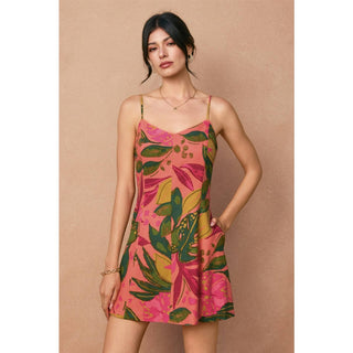 Woman wearing a colorful floral dress against a beige background