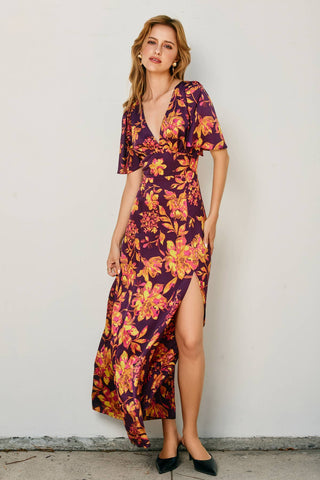 Woman wearing a floral dress against a plain background